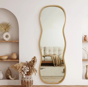 This fluid, wavy full-length <b>wall</b> <b>mirror</b> showcases a smooth natural wood frame outline available at wholesale prices. - Product Image 1