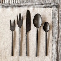Ensemble de couverts en métal élégant avec finition noire mate, parfait pour sublimer l'apparence des tables de repas lors de fêtes et de dîners