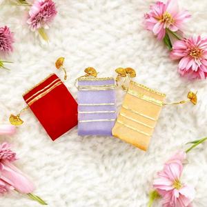 Élégance festive pour les célébrations avec un ensemble de pochettes potli artisanales, pochettes à cordon de serrage aux couleurs rouge intense, lavande douce et tons dorés chauds. - Product Image 1