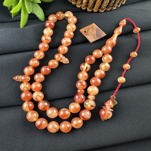 Warm amber-<b>toned</b> smooth round tasbih prayer beads attached to an elegant matching <b>red</b> cord, available at wholesale prices. - Product Image 1