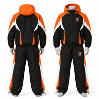 Ensemble de survêtement pour homme noir, orange et blanc avec blocs de couleur, veste coupe-vent zippée intégrale et pantalon sportif avec logo imprimé