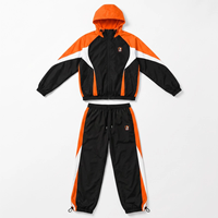 Ensemble de survêtement pour homme noir, orange et blanc avec blocs de couleur, veste coupe-vent zippée intégrale et pantalon sportif avec logo imprimé