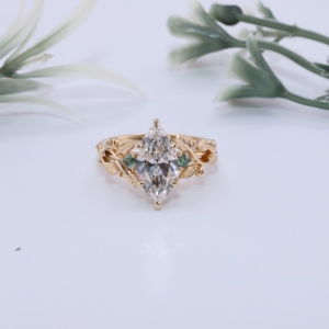 Bague de fiançailles vintage en or jaune avec diamant de laboratoire taille marquise, saphir vert inspiré de la nature en forme de feuille de vigne, halo caché, bijoux fins - Product Image 1