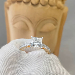 Elegante diamante talla princesa engastado en lujoso oro amarillo de 10K/14K/18K, flanqueado por deslumbrantes piedras laterales para un anillo sofisticado. - Product Image 1