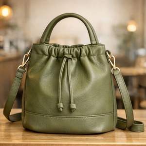 Ce produit ressemble à un sac à main structuré en cuir clair avec poignée supérieure, similaire au sac à bandoulière en cuir Vela. - Product Image 3