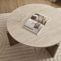Table basse ronde au look travertin moderne avec pieds larges pour salon