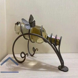 Wrought iron scrollwork single wine bottle holder stand <b>topped</b> with a decorative <b>butterfly</b>, available at wholesale prices. - Product Image 1