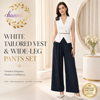 Costume élégant pour femmes, sans manches et cintré à la taille, en noir et blanc, adapté aux occasions formelles.