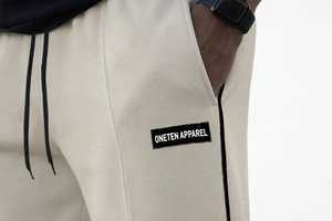 กางเกงวอร์มขายาวสีเบจสำหรับผู้ชาย ยี่ห้อ Oneten Apparel แต่งแถบสีดำด้านข้าง มีเชือกผูกเอว ทรงตรง สวมใส่สบาย ผลิตจากโพลีเอสเตอร์ 100% เนื้อผ้าบางเบา - Product Image 4