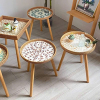 Table basse élégante et discrète de style bohème en rotin tressé, avec plateau incrusté de nacre et finition artisanale Wabi.