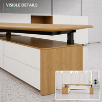 Bureau de travail moderne en forme de L, réglable en hauteur, avec plateau en bois grainé, rangement latéral blanc, colonnes de levage noires, usage commercial