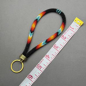 Porte-clés de poignet tendance fait main pour femme, orné de perles, motifs noir, rouge, orange, jaune, turquoise, blanc, avec anneau doré, pour usage quotidien - Product Image 1
