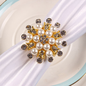 Exquises bagues à serviettes en métal en forme de nœud papillon avec des perles blanches contribuent à créer une ambiance de repas calme et bien organisée. - Product Image 2