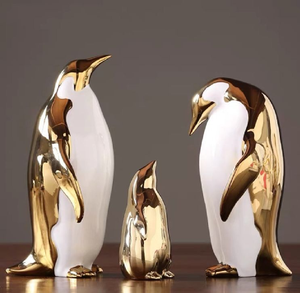 Modernas estatuas de pingüinos de cerámica en dorado y blanco con un acabado pulido de alto brillo; disponibles a precios de mayorista. - Product Image 1