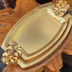 Ensemble de plateaux rectangulaires élégants en métal doré avec poignées décoratives en forme de fleurs pour un service chic et une présentation raffinée sur la table. - Product Image 2