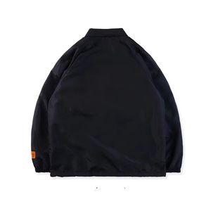 Veste coupe-vent noire pour homme avec accents de manches orange, ourlet rouge, cordon de serrage, boutons-pression, manches raglan et col rabattable - Product Image 5