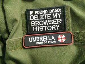 Patch brodé rectangulaire Umbrella Corporation à thermocoller, noir avec bordure rouge et texte blanc, pour utilisation sur tissu - Product Image 1