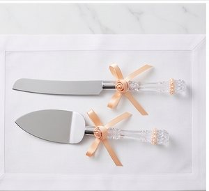 Elegante juego de cuchillo y espátula para pastel de bodas con mangos de cristal y detalles de cinta color melocotón para uso en fiestas. - Product Image 3
