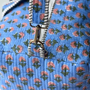 Sac de voyage matelassé bleu à motifs floraux avec poignées rayées, fermeture éclair, design portable pour un usage décontracté en voyage - Product Image 2