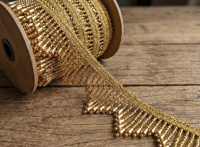 Dentelle tressée Zig-Zag Premium Or avec pompons de perles vibrantes et franges de perles géantes pour la confection de Lehngas et de robes de luxe