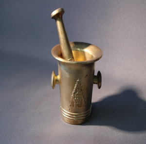 Cylindrical golden brass mortar pestle set with side knobs and decorative motif reliefs, available at wholesale prices. - Product Image 1