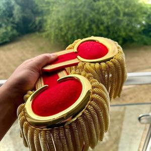 อีโบลเล็ตต์รูปพระจันทร์สีทองสำหรับวงโยธวาทิต พร้อมพู่ห้อยลายเกลียวสีทองหนักๆ บนพื้นหลังสีแดง - Product Image 4