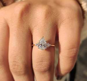 Élégante bague en forme de poire avec grappe de diamants et accents ronds étincelants, un chef-d'œuvre de joaillerie de luxe pour fiançailles, anniversaire ou mariage. - Product Image 4