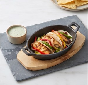 Sartén ovalada de hierro fundido con base de madera para servir bistec, mariscos, verduras y platos calientes en restaurantes. - Product Image 6