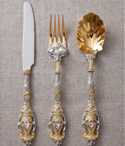 Ensemble de couverts élégants plaqués or et argent avec poignées ornées, idéal pour les tables de mariage. - Product Image 1