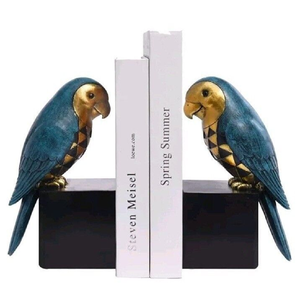 Sujetalibros con diseño de loro en colores verde azulado y dorado vibrantes, posados sobre bloques negros, que aportan un toque tropical a tu hogar. Disponible a precios de mayorista. - Product Image 1
