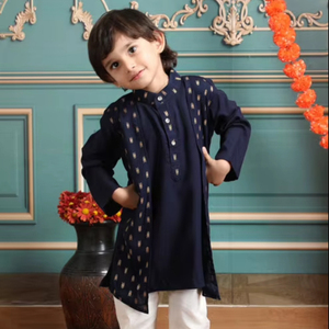 Adorable niño con kurta y pijama tradicionales, de pie con pétalos de flores, en un ambiente festivo de estudio interior con pared decorativa. - Product Image 1