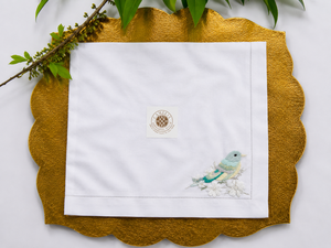 Serviette brodée d'oiseaux et de fleurs blanches, offrant un look épuré pour une mise en scène polyvalente. - Product Image 1