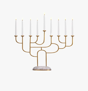 Menorá artística de metal dorado con ramificaciones, base de piedra y nueve velas encendidas. Está disponible a precios de mayorista. - Product Image 1