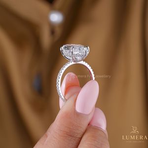 Bague de luxe en or avec diamant de laboratoire ovale taille étagée exquise, halo micro-pavé dissimulé, profil panier ouvert et bande pavée brillante - Product Image 5