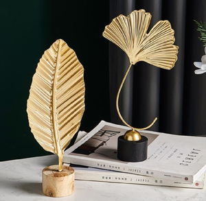 Elegantes esculturas de hojas de ginkgo y palma doradas sobre bases minimalistas. Decoración moderna para el hogar disponible a precios de mayorista. - Product Image 1