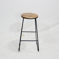 Tabouret de bar ComeHome avec assise en bois d'acacia naturel, pieds en fer thermolaqué noir et patins rectangulaires en plastique