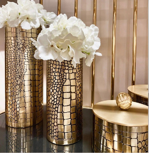 Vases cylindriques contemporains en métal doré avec un motif texturé imitation peau de serpent ou de galet. Disponible à prix de gros. - Product Image 1