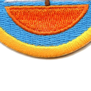Patch thermocollant circulaire avec motif de voilier brodé, fond bleu, coque orange, voiles blanches, bordure jaune - Product Image 6