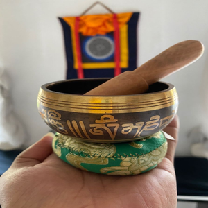 Cuenco de latón poco profundo con grabado de un motivo facial tradicional y borde floral, disponible a precios de mayorista. - Product Image 3