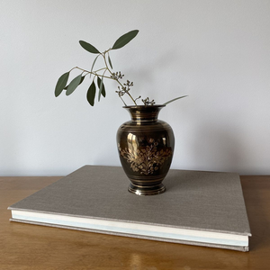 Sofisticado florero de latón oscuro con borde pulido y un grabado central de ramo dorado. Disponible a precio de mayorista. - Product Image 1