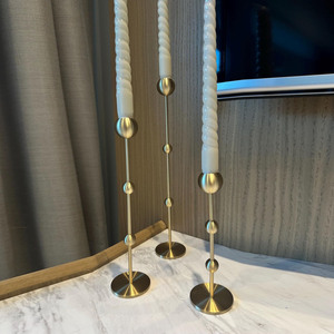 Ensemble de chandeliers élégants en métal doré avec un design unique de boules et de tiges, pouvant accueillir trois bougies coniques pour une décoration intérieure chic - Product Image 4