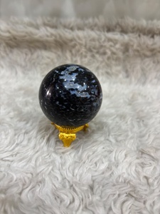 Esfera de gabbro índigo con tonos gris azulado oscuro, patrones minerales marrones, forma redonda pulida y características geológicas distintivas. - Product Image 1