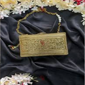 Barrel-shaped golden <b>brass</b> hand clutch with detailed floral engraving, a classic lock, and bottom <b>bell</b> charms, at wholesale. - Product Image 2