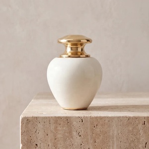 Urna Moderna de Metal Color Marfil con Tapa Dorada Esculpida, Cuerpo Curvo Liso y Diseño Compacto para Homenaje Conmemorativo - Product Image 3