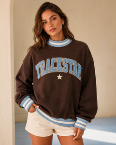 เสื้อสเวตเชิ้ตคอกลมสีน้ำตาลช็อกโกแลต Trackstar แต่งแถบสีน้ำเงินขาว ตัวอักษรสีฟ้าคราม ลายดาวสีครีม แขนยาว - Product Image 1