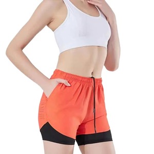 Shorts de sport pour homme orange avec poches, séchage rapide, taille élastique, longueur mi-cuisse, couleur unie, tricoté en spandex et polyester - Product Image 1