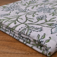 Tissu en coton imprimé à la main, motif floral blanc et vert traditionnel, design feuilles et vigne, idéal pour la confection de vêtements et la décoration.