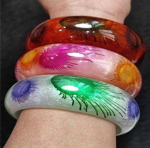 Chunky <b>clear</b> <b>resin</b> bangle filled with bright orange and pink dried garden flowers, available at wholesale prices. - Product Image 4