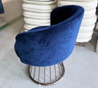 Fauteuil lounge en velours bleu foncé, dossier bas incurvé, base en fil métallique, design moderne pour hall d'hôtel, salon, bar, restaurant