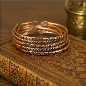 Conjunto de Brazaletes Abiertos Nórdicos con Pátina de Bronce, Grabados a Mano con Motivos Primitivos y Terminales en Forma de Paleta - Product Image 1
